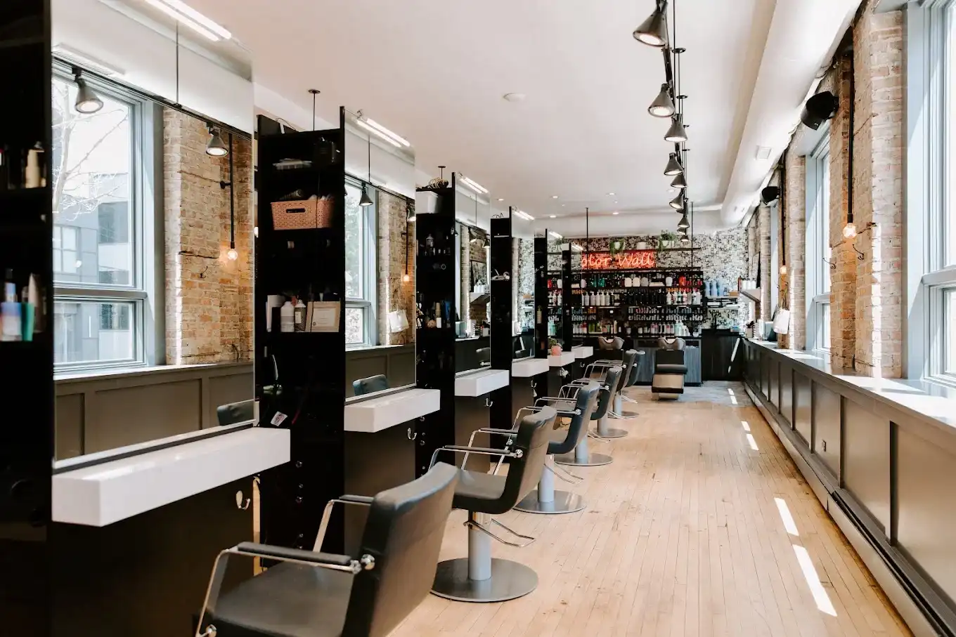 Modern hair salon with styling stations and brick walls. Bright and spacious interior.